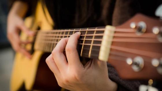 Hands playing a guitar